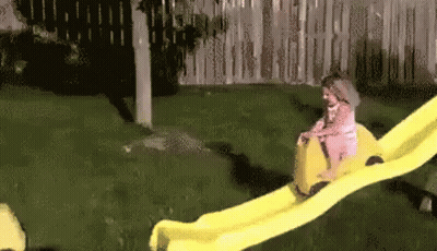 Little Girl Riding Yellow Slide GIF