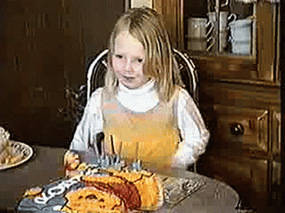 Little Girl Sitting At Table With Birthday Cake And Nuggets GIF