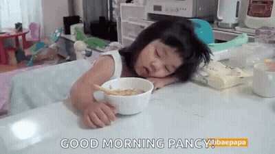 Little Girl Sitting At Table With Bowl Of Cereal GIF