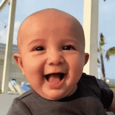 Little Girl Sitting In Front Of Door Looking At Camera GIF