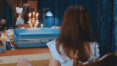 Little Girl Sitting In Front Of Suitcase With Candles GIF