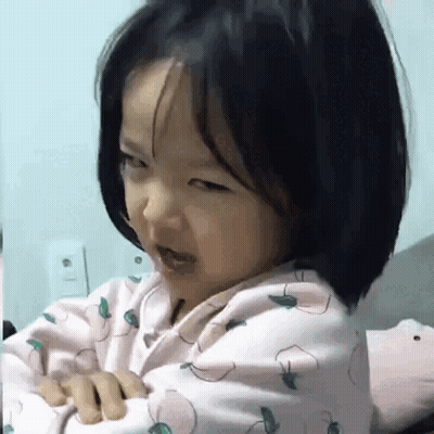 Little Girl Sitting On Bed Making Funny Face GIF