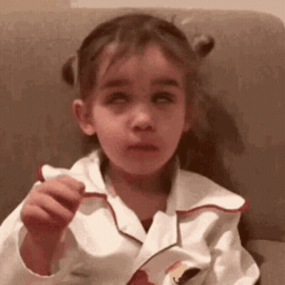 Little Girl Sitting On Couch Holding Food GIF