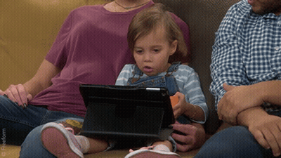 Little Girl Sitting On Couch Looking At Tablet With Freeform Logo GIF