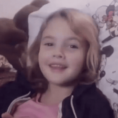 Little Girl Smiling On Bed GIF
