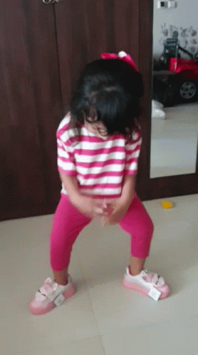 Little Girl Squatting in Striped Shirt and Pink Pants