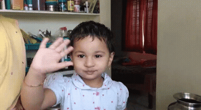 Little Girl Waving Hand In Room GIF