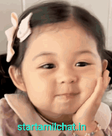 Little Girl With Bow Smiling Hand On Chin GIF