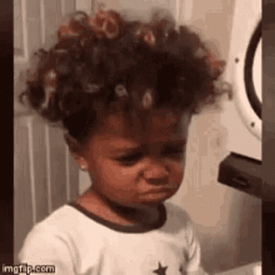 Little Girl With Curly Hair Crying In Front Of Washer And Dryer GIF