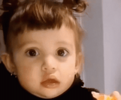 Little Girl With Pigtails Looking At Camera GIF
