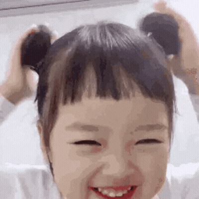Little Girl With Pigtails Smiling Holding Hair GIF
