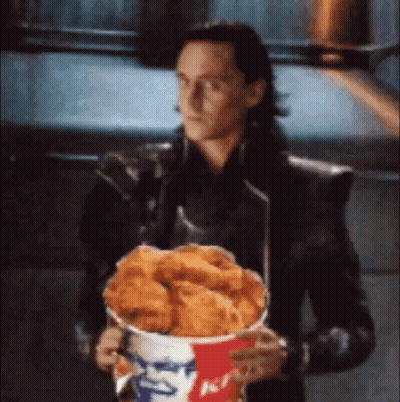 Loki Is Holding A Bucket Of Fried Chicken In His Hands . GIF