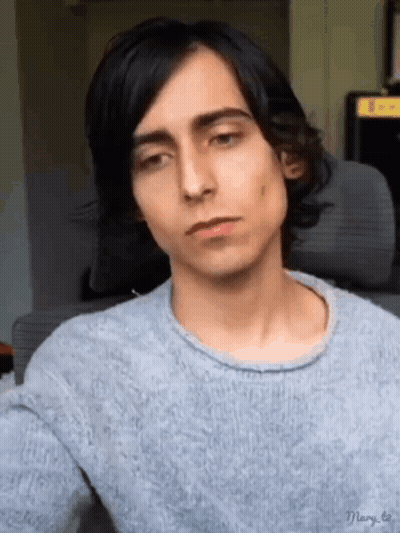 Long-Black-Haired Young Man Gray Sweater Looking At Camera GIF