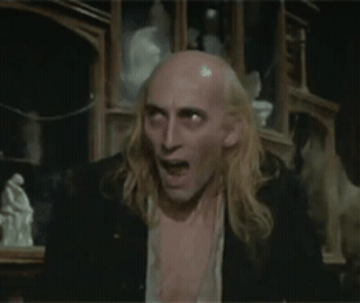 Long Blonde Hair Bald Man Shirtless In Dark Room GIF