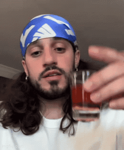 Long Haired Bearded Man With Blue White Headband Holding Shot Glass GIF