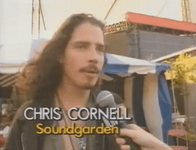 Long-Haired Man Holding Chris Cornell Mic GIF