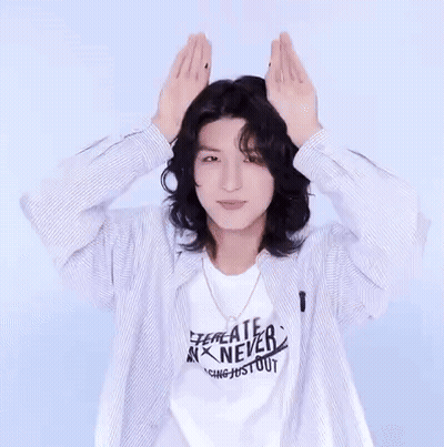 Long Haired Man In Striped Shirt Making Heart GIF