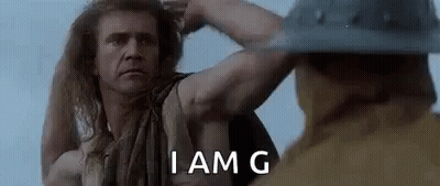 Long Haired Man Next To Man In Helmet Holding Hair GIF