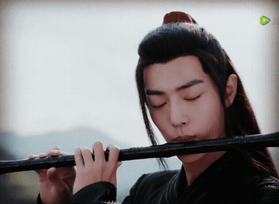 Long-Haired Man Playing Flute Before TV Saying Play GIF