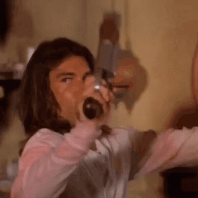 Long-Haired Man Screaming With Bottle In Mouth GIF