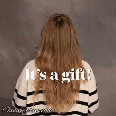Long Haired Woman In Striped Sweater Saying It's A Gift GIF