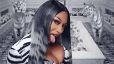 Long-Haired Woman Sticking Tongue Out At Tiger Statues GIF
