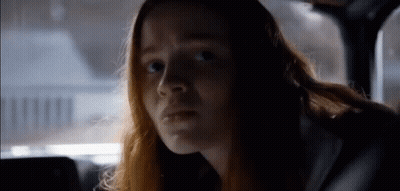 Long Red-Haired Woman In Car Looking At Camera GIF