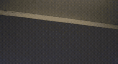 Looking Up At A Very Tall Building With A Cloudy Sky In The Background GIF