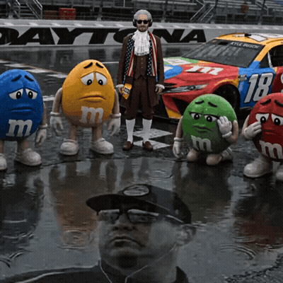 M&Ms Standing In Front Of Daytona Race Car GIF