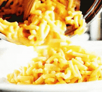 Macaroni And Cheese Is Poured Into A White Bowl GIF