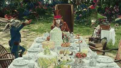 Mad Hatter Sitting At Table With Cakes GIF
