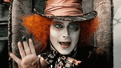 Mad Hatter Sitting In Chair With Hand Out GIF