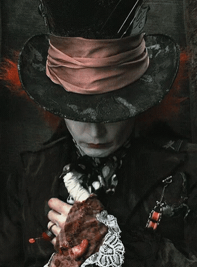 Mad Hatter Wearing Hat And Scarf Holding Meat GIF