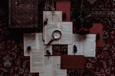 Magnifying Glass On Books Saying Agatha Christie GIF