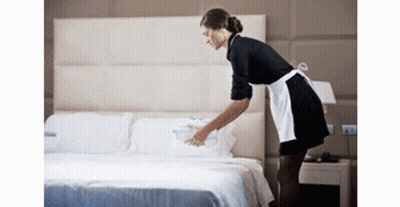 Maid In Apron Making Bed In Hotel Room GIF
