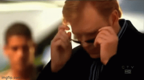 Man Adjusting Glasses Behind Woman GIF