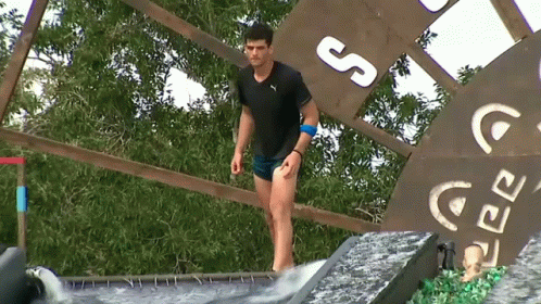 Man Adjusting Hair In Front Of Survivor TV GIF