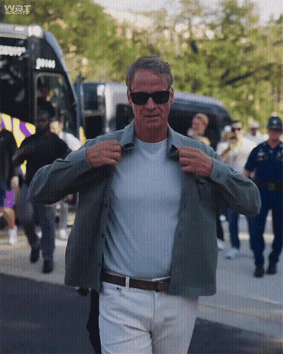 Man Adjusting Shirt In Front Of Bus Saying Wat Sports GIF