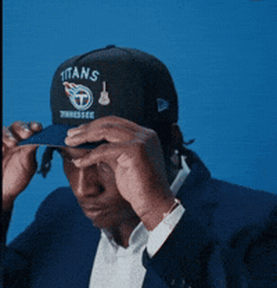 Man Adjusting Titans Hat GIF