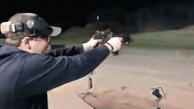 Man Aiming Gun At Target At Night GIF