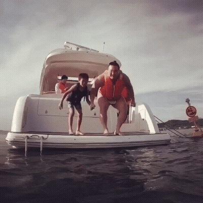 Man And Boy Jumping Off Boat Into Water GIF