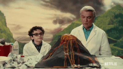 Man And Boy Looking At Volcano Model With Netflix Logo GIF