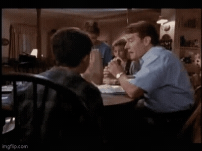 Man And Boy Sitting At Table In Living Room GIF