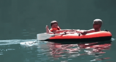 Man And Child On Raft In Water GIF