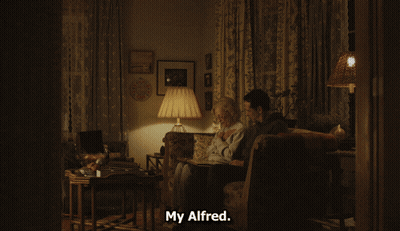 Man And Elderly Woman With Photo Album Saying But He Got Bit By Animal GIF