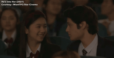 Man And Girl Looking At Each Other In Movie Theatre GIF