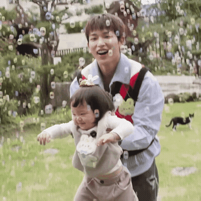 Man And Girl Playing With Soap Bubbles GIF