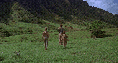 Man And Two Children Running In Grassy Field With Mountains GIF