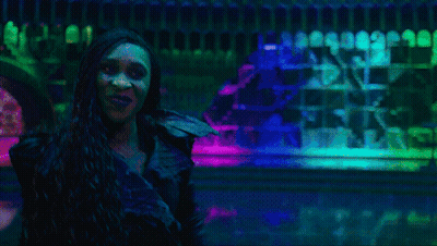 Man And Two Women Dancing Under Purple Lights GIF