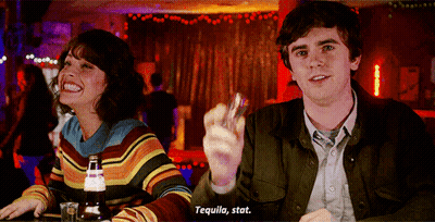 Man And Woman At Bar Holding Shot Glass Says Tequila Stat GIF
